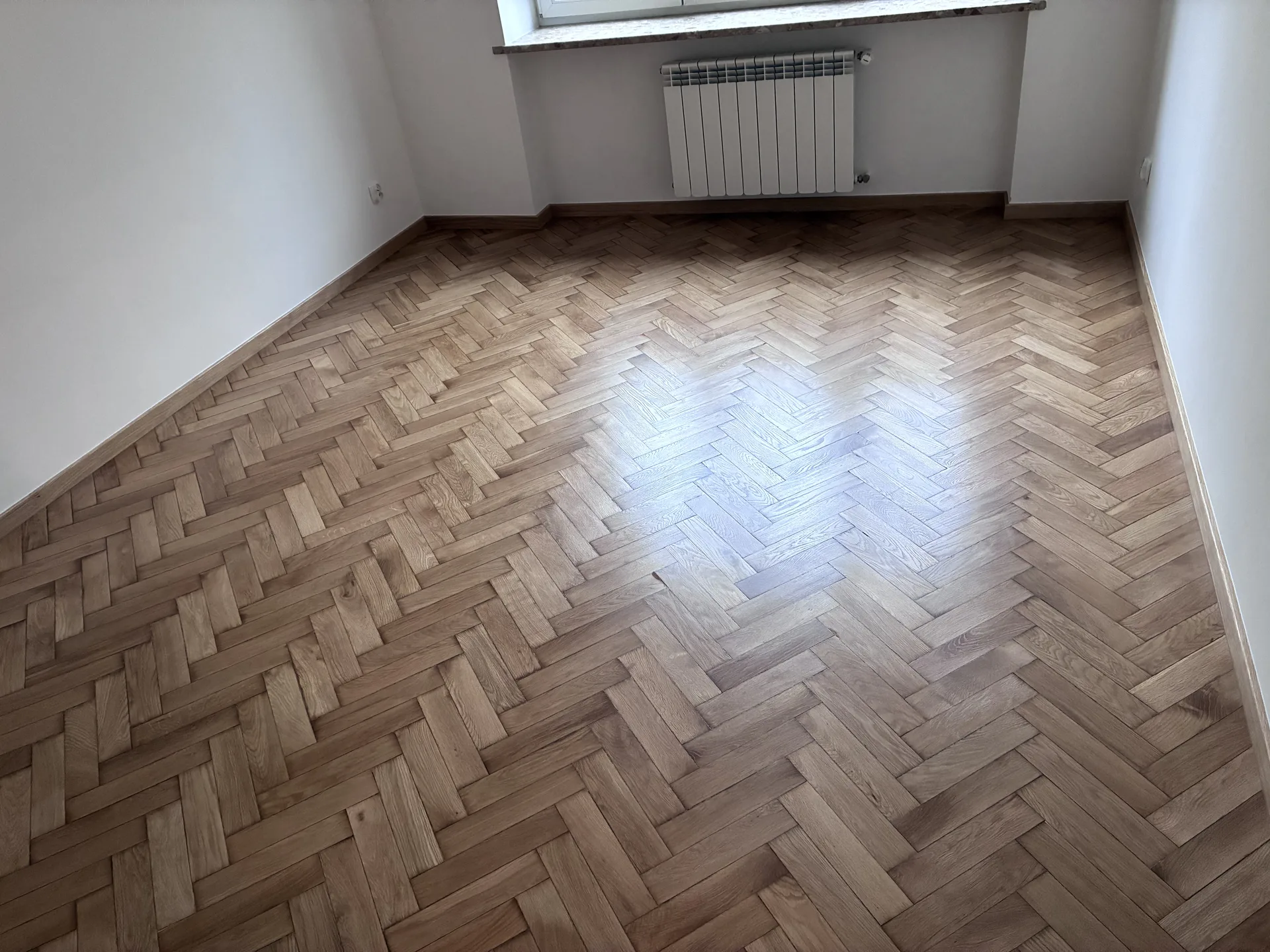 Zużyta podłoga jodełkowa w szkole